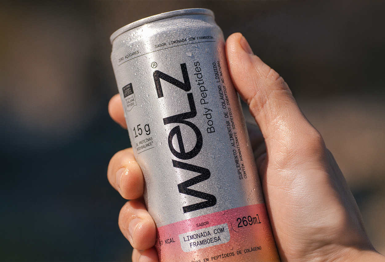 Mão segurando uma lata gelada de Welz Body Peptides sabor limonada com framboesa